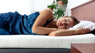 A woman with dark hair sleeps on the Viscosoft Active Cooling Mattress Topper