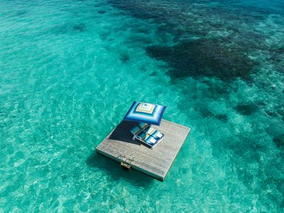 Blue missoni patterned parasol and lounger on blue sea at One &amp; Only Reethi Rah Maldives resort