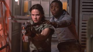 Cailee Spaeny takes point with a rifle while David Jonsson follows worriedly behind her in Alien: Romulus,