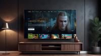The new Prime Video home page with Lord of the Rings: The Rings of Power as the main featured content. This is showing on a TV in a modern living room with a lamp. media unit and plant visible.