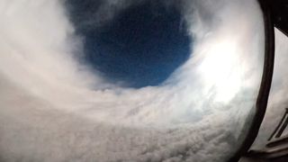 a circle of clouds with a black hole in the center