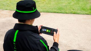 A man wearing a Razer jacket plays the Razer Edge handheld console