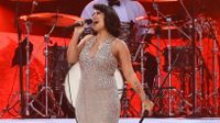 RAYE performs onstage in a glittery silver dress ahead of her performance at the 'American Music Awards' 2024