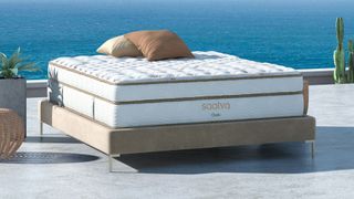 DreamCloud vs Saatva: The Saatva Classic mattress photographed against the backdrop of a blue ocean