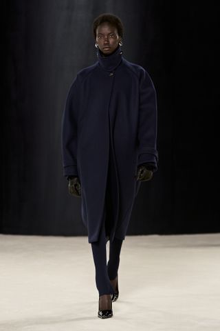 Woman on Ferragamo runway in navy coat