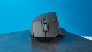 A photo of the Logitech MX Master 3S on a black slate against a blue background.