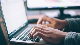 Fingers typing on a keyboard.