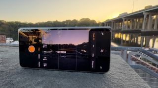 OnePlus Open med kameraappen öppen och riktad mot en bron under en soluppgång.