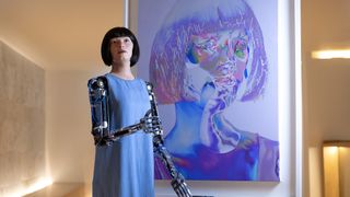 The robot artist "Ai-Da" stands in front of one of her self-portraits during the opening of her new exhibition at the Design Museum in London on May 18.