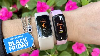 Two Fitbit devices on a person&#039;s wrist with the Tom&#039;s Guide Black Friday deals badge