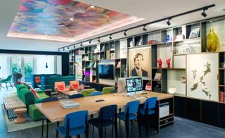 Seating area featuring a work area, artwork, shelving, and a mural on the ceiling