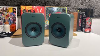 Green pair of KEF LSX II LT in front of vinyl records