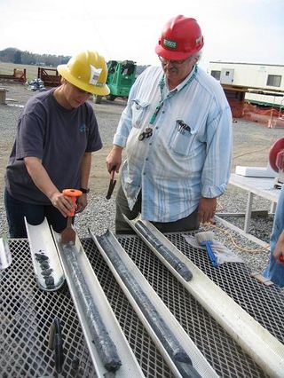 Mary Voytek and Greg Gohn of the USGS select a section of a freshly-retrieved core for biological sampling.