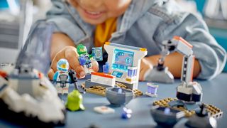closeup of a child playing with legos on a blue table