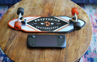 Steam Deck console next to a skateboard