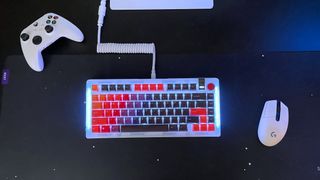 The Glorious GMMK 3 gaming keyboard seen from above on a black desk with a mouse and game controller