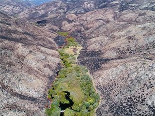 A view of a lush area amid barren mountains.