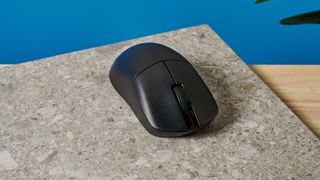 A black Lemokey G1 wireless gaming mouse sitting on a marble slab