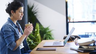 Studerende ser video med en kop kaffe på et bibliotek