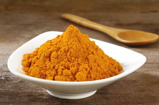 Turmeric powder sits in a bowl