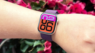 Apple Watch Series 10 on a person's wrist in front of some pink flowers