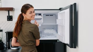 Woman with freezer compartment door open