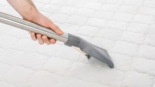 Vacuum cleaning a white mattress