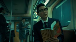 Ben Hargreeves smiles as he looks up from a book on the Korean subway network in The Umbrella Academy season 3 finale's mid-credits scene