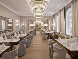 restaurant with grey curved chairs and chandeliers at The Hotel Maria