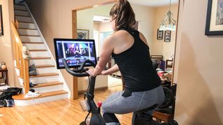 Woman riding a Peloton Bike at home