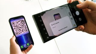 A Samsung Galaxy S22 Ultra scanning a Wi-Fi QR code from an iPhone 13 Pro Max