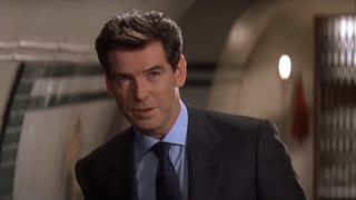 Pierce Brosnan stands smiling in disbelief in Q's lab in Die Another Day.