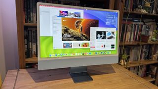 The 2023 M3 iMac on a wooden desk, showing the features of macOS Sonoma