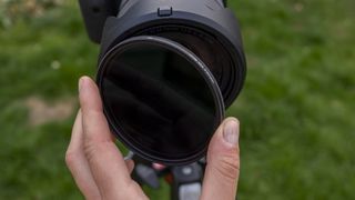 The Kenko Pro1D Variable ND filter being screwed onto a Canon lens