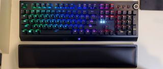 black full-size keyboard with wrist rest against white desk