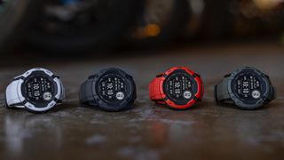 Four Garmin Instinct 2X Solar watches sitting side-by-side on a table