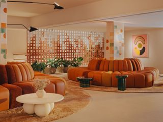 Hyde Ibiza lobby area boasting orange sofas and a whimsical wallpaper