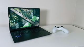 The Asus Vivobook S14 running Death's Door on a white table next to a game controller