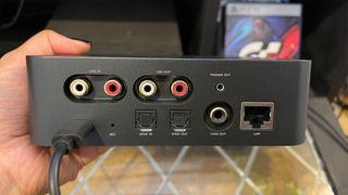 The back of WiiM Pro Plus unit showing all the connections, held in hand