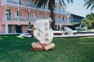 man reads newspaper on hotel lawn