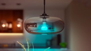 A Philips Hue A67 smart HomeKit lightbulb inside an overhead kitchen lamp.