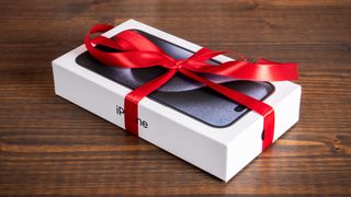 An iPhone 15 Pro wrapped in ribbon on a table