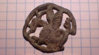 A pilgrim's badge with a symbol of a basilisk.