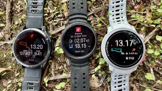 A Garmin Fenix 8, Polar Vantage M3, and COROS PACE Pro watch sitting next to each other on the grassy ground, showing their respective results summary screens for a 13-mile run.