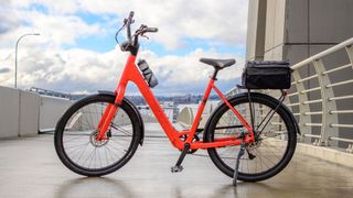 The Verve+ 1 Lowstep LT bike in red on a bridge with a blue sky.