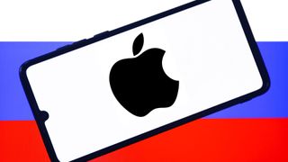 Apple logo is displayed on a mobile phone screen photographed with Russian flag in the background for the illustration photo taken in Poland on July 19, 2022. 