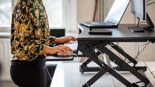 a photo of a woman working at a standing desk