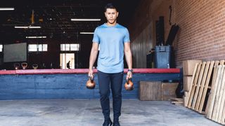 Man performing a farmer's hold with two kettlebells holding one in each hand