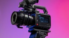 Blackmagic Pyxis 6K camera in the studio, mounted to video tripod, with a vibrant magenta background