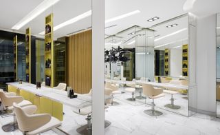 Spa chairs in front of a white counter with a mirror in front of it